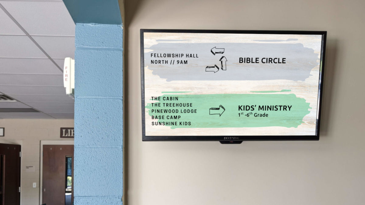 A digital signage TV showing directions in a church hallway.
